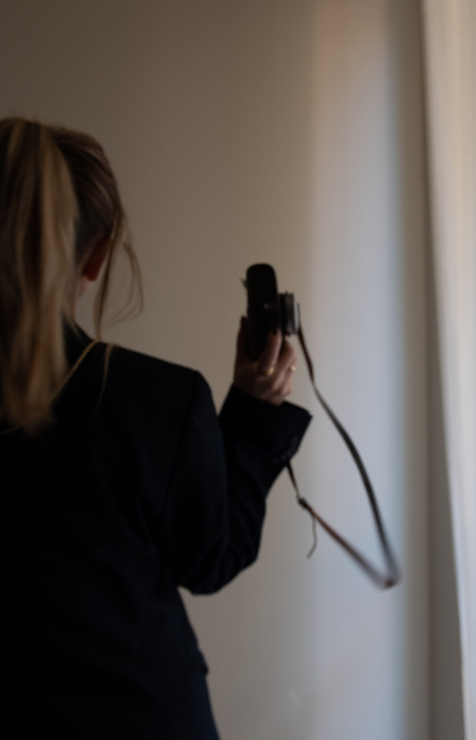 Photographer holding a camera in a softly lit studio